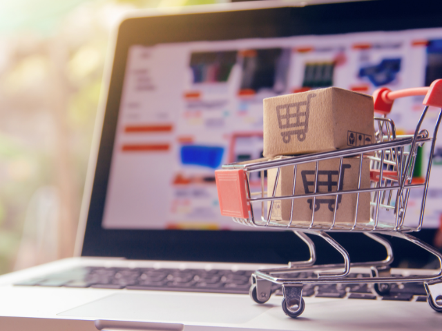 Carrinho em laptop com site de e-commerce — ilustra compras online.