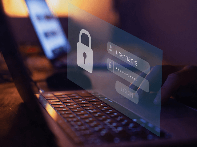 Mãos digitando em um notebook com projeção digital de tela de login e ícone de cadeado, representando autenticação e proteção cibernética.